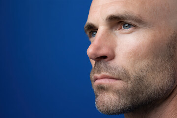 Fototapeta premium navigator portrait on bright ultramarine background focused expression face positioned on right side of frame