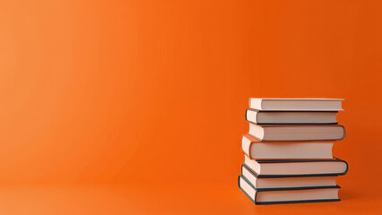 Fototapeta premium On a orange background there is a stack of books