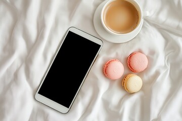 Smartphone, coffee, and macarons on a bed
