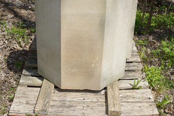 cut stone object with flat sides on a skid outdoors