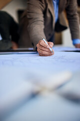 Business Professional Working on Blueprint with Focus and Precision in Office Environment