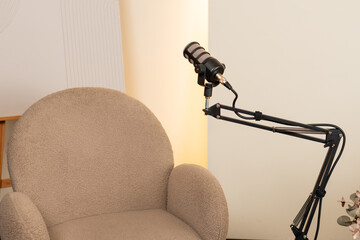 Podcast setup featuring a microphone and an empty chair ready for an engaging interview discussion in a cozy studio