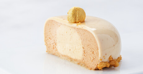 Horizontal Banner of Praline Hazelnut Mousse Cake Cut in Half with Glossy Glaze and Copy Space.