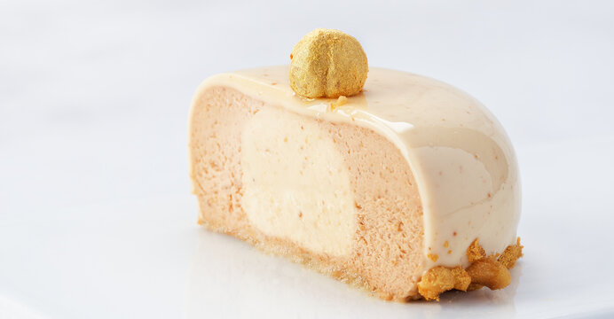 Horizontal Banner of Praline Hazelnut Mousse Cake Cut in Half with Glossy Glaze and Copy Space.