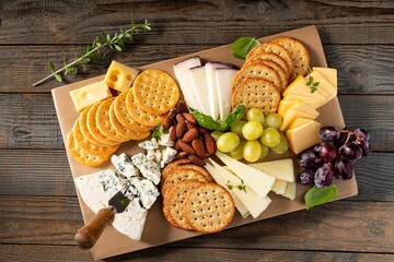 Cheese plate or board with variety of cheese, crackers, nuts and grapes