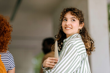Students engaged in conversation on college campus with smiling expressions and focus on academic...