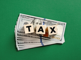 Tax concept with wooden cubes on dollar banknotes