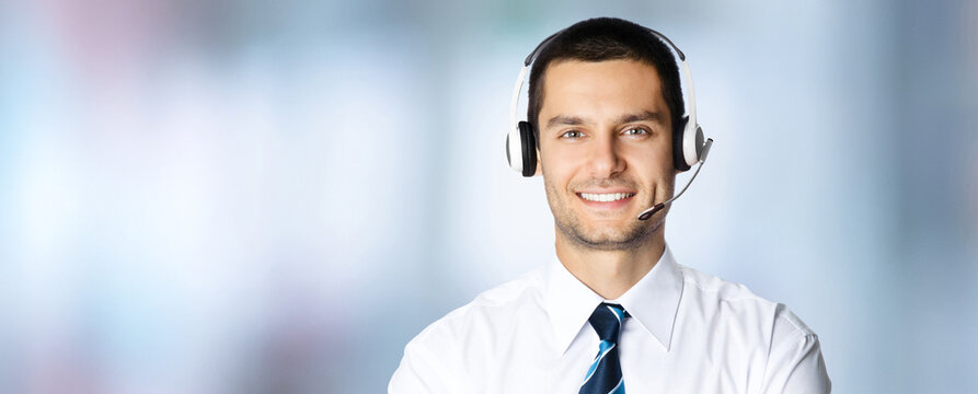 Call Center Service. Face portrait - happy smile customer support callcenter sale agent. Phone operator business man businessman in headset on blurred office background Banner image with ad free space