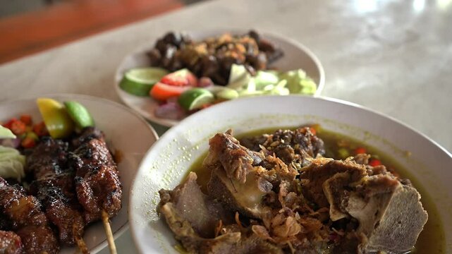 Three delicious Indonesian food dishes with traditional dishes such as beef satay, Yogyakarta beef tengkleng, and ati ampla which are blur video. Ideal for promoting authentic Indonesian cuisine.