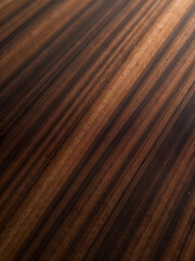 A close-up view showcases the detailed patterns and textures of a beautiful, dark wood surface.