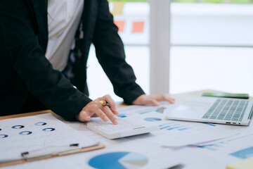 Asian female accountant businesswoman analyze using laptop to collect financial data in office. Business finance, tax and accounting concept.