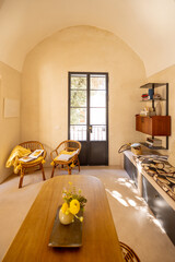 Cozy reading corner with rattan chairs, yellow cushions, and open books bathed in morning sunlight. Serene interior scene from a Mediterranean-style home