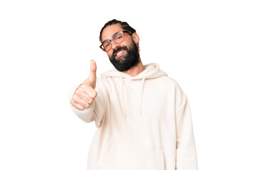 Fototapeta premium Young man with beard over isolated chroma key background with thumbs up because something good has happened