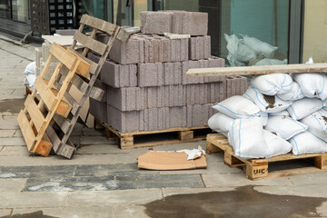 Construction materials and sandbags near modern glass building