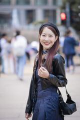A woman wearing a black jacket and a black hat is smiling
