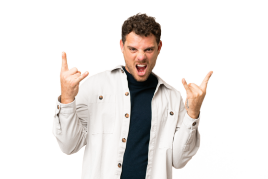 Brazilian man over isolated chroma key background making horn gesture