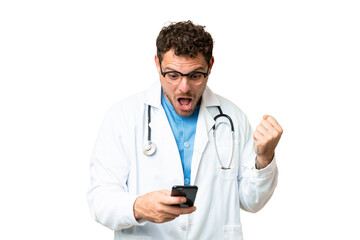 Fototapeta premium Brazilian doctor man over isolated chroma key background surprised and sending a message