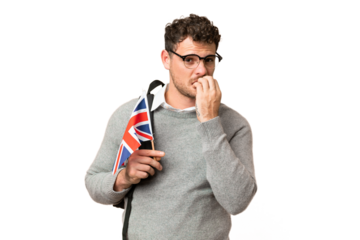 Brazilian man holding an United Kingdom flag over isolated chroma key background having doubts