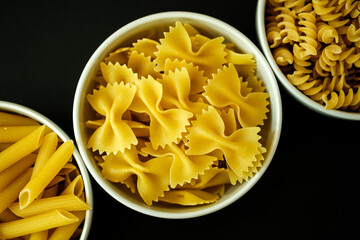  Three bowls of Healthy Farfalle, Penne and Fusilli Italian Pasta Ready to Cook