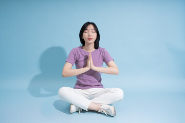 Fototapeta premium Meditation session in a serene indoor space with calming blue background and focused individual practicing mindfulness