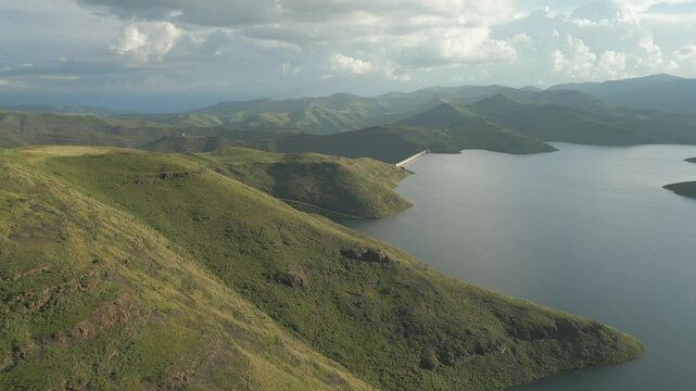 Aerial rise to reveal Mohale Dam wall and distant green mountains in Lesotho 