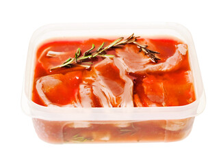 Premium quality marinated lamb loin chops in plastic container on white background. Uncooked raw meat on the bone in red color water based marinade to enhance dish taste.