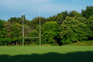 Training ground in a park with tall goal post for popular Irish national sports camogie, hurling, rugby, football, Warm sunny day, blue sky. Soccer field. Outdoor activity. Team game equipment. © mark_gusev