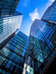 Modern glass skyscrapers ascend towards a vibrant blue sky, their reflective surfaces capturing the sunlight and clouds.  A low-angle perspective emphasizes their towering height and a : Generative AI