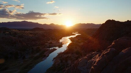 Fototapeta premium Serene sunset over a meandering river, nestled within a rugged mountain range, bathed in warm golden light. : Generative AI