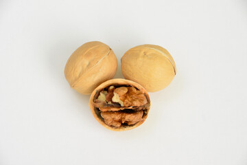 walnuts with one cracked open on white surface