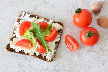Curd Cheese Sandwich with Fresh Arugula and slices of cherry tomato decorated with tomatoes