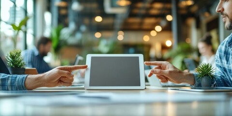 Two colleagues collaborate, pointing at a tablet screen displaying a blank interface in a modern, brightly lit coworking space. : Generative AI