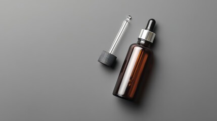 Brown Glass Dropper Bottle with Pipette on Grey Surface