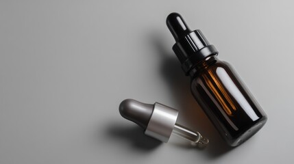 Fototapeta premium Glass dropper bottles with liquid on smooth gray surface