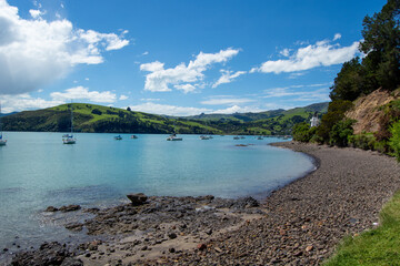 Serene Coastal Bay with Sailboats and Green Hills