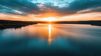 Fototapeta premium Stunning sunset over a calm lake, with golden light reflecting on the water, surrounded by tranquil hills and a vibrant sky. : Generative AI