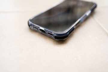 Smartphone in shockproof silicone case on tiled floor after falling.