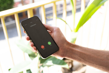 Fraud or fraudulent schemes. Close-up of a male hand holding a phone with an unexpected incoming...