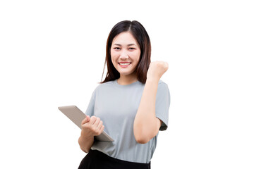 Asian beautiful Young woman smiling and holding a tablet while making a triumphant fist gesture.