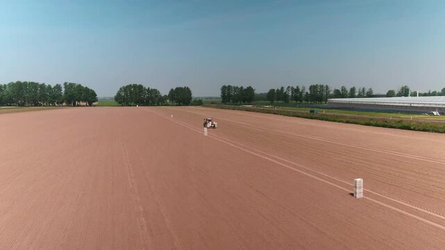 Drone Footage of Modern Tractor Sowing Seeds on Farmland in Germany &ndash; Aerial View of Agriculture