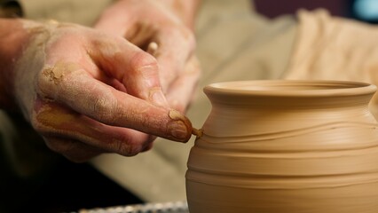 Close up potter using professional equipment man male master skill hobby art artcraft creating patterns clay pottery bowl jug vase craftsman small business workshop studio handwork handmade decoration