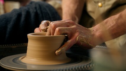 Man hands sculpting clay modeling professional male master potter pottery creating formed vase jug...