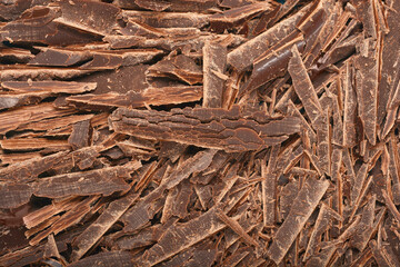 A close-up shows a pile of dark chocolate shavings with a rich, textured surface