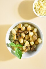 Potato gnocchi with mushrooms, cheese and greens