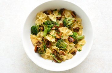 Farfalle pasta with roasted broccoli and mushrooms in bowl