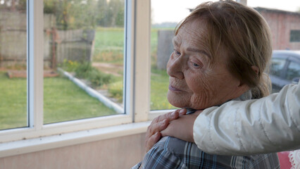 Child putting hand on shoulder of sad elderly woman. Support and care in family. Care for old in a...