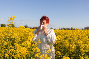 Mature woman with handkerchief suffering from allergy to flowering plants