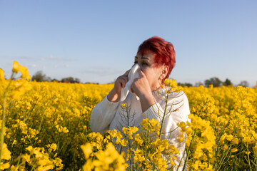 Mature woman with handkerchief suffering from allergy to flowering plants