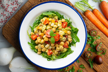 Mediterranean chickpea salad with avocados and vegetables. Top view table with christmas decorations.