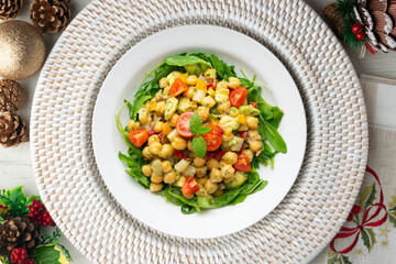 Mediterranean chickpea salad with avocados and vegetables. Top view table with christmas decorations.